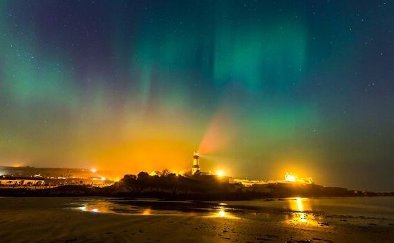 Een vuurtoren verrijst majestueus onder de gloeiende lichten aan de hemel. Een must-see tijdens elke vakantie in Ierland. | Echt Ierland Vakanties