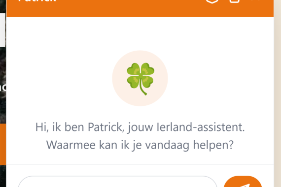 Er verschijnt een chatvenster met de naam Patrick en een oranje kop. In het midden staat een klavertjevier-icoon. Daaronder staat de Nederlandse tekst: Hallo, ik ben Patrick, jouw Ierland-assistent. Een tekstvak en verzendknop staan onderaan. | Echt Ierland Vakanties