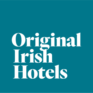 Witte vetgedrukte schreefloze tekst met Original Irish Hotels staat in het midden op een groenblauwe achtergrond, waardoor een eenvoudige en moderne look ontstaat - perfect om te presenteren als jubileumcadeautje. Er zijn geen extra afbeeldingen of grafieken inbegrepen. | Echt Ierland Vakanties