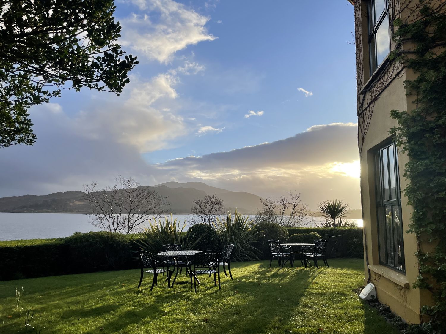 Tuin met uitzicht over baai en bergen, Ierland